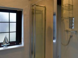 a shower with a glass door in a bathroom at Ikkle Cottage in Blidworth