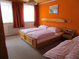 1 dormitorio con 2 camas y paredes de color naranja en Nockhof, en Neustift im Stubaital