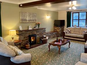 a living room with a couch and a fireplace at Hayscastle Farmhouse in Hayscastle