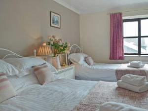 a bedroom with two beds and a window at Hayscastle Farmhouse in Hayscastle