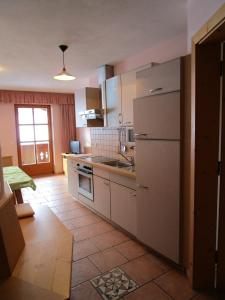 a kitchen with a white refrigerator and a tile floor at Nockhof in Neustift im Stubaital