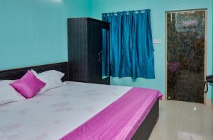 a bedroom with a bed with pink and blue walls at deb Guest House And Banquet hall in Kolkata