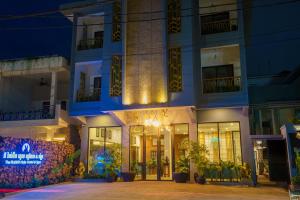 un edificio con un cartel delante de él por la noche en The Rabbit Hole Hotel & SPA, en Siem Reap