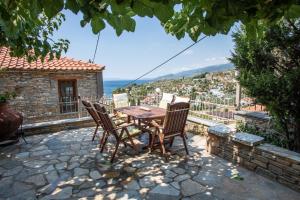 una mesa y sillas en un patio con vistas en ¨Με θέα το ηλιοβασίλεμα¨, en Áfissos