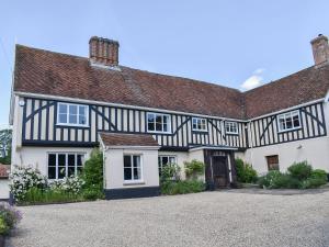 a large black and white house with a driveway at Coachmans Cottage - Uk11449 in Mellis