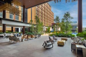 un patio al aire libre con sillas y mesas en un edificio en M Resort & Hotel Kuala Lumpur en Kuala Lumpur