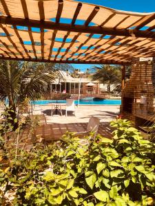 pérgola de madera sobre un patio con piscina en Exelente Apartamento Porto das Dunas, en Aquiraz
