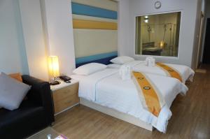 two beds in a hotel room with a mirror at Phanhin Regent 304 -SHA Extra Plus in Si Maha Phot