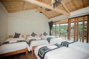 a group of four beds in a room with windows at Bong Bang homestay 2 in Na Hang
