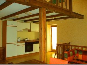 a kitchen with white cabinets and a table in a room at Kotedzas Melnrageje in Klaipėda