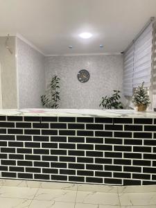 a black and white counter with a clock on a wall at Tarmansky Hotel in Tyumen