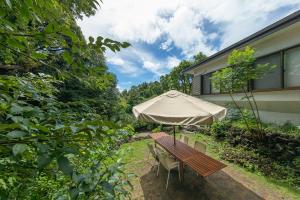 un tavolo da picnic con ombrellone in un cortile di YAMO-Izukogen a Yawatano