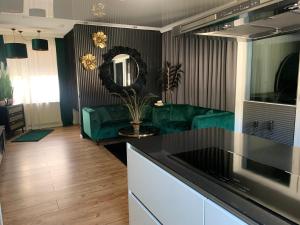 a kitchen and living room with a green couch at Lans Apartments SPA Menden Sauerland in Menden