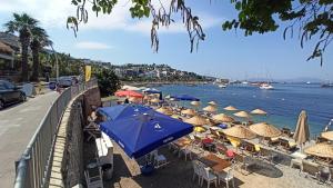 plaży z parasolami i krzesłami oraz wodą w obiekcie Private old stone building in the center of Bodrum 1plus1 w Bodrum