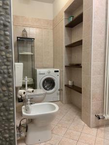 ein Badezimmer mit einer Waschmaschine und einem WC in der Unterkunft Casa Luisini in Mondovì