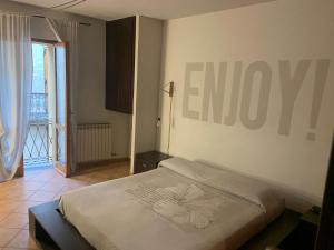 a bedroom with a bed with a sign on the wall at Casa Luisini in Mondovì