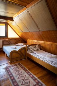 a room with two beds in a wooden house at Pensiunea Novac in Durau