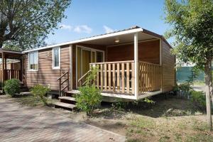 a wooden cabin with a porch and stairs to it at Camping Grande Italia Maddalena 6 in Chioggia