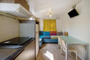 a kitchen with a table and a room with a bed at Camping Grande Italia Maddalena 6 in Chioggia