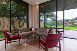安朱納的住宿－StayVista Bella Antlia 3BHK, with Pvt Pool & Paddy view- Parra, North Goa，客厅配有沙发、椅子和桌子
