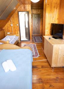 Habitación con cama y TV. en Pensiunea Novac en Durau