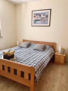 ein Schlafzimmer mit einem Bett mit einer karierten Decke in der Unterkunft Roky in Povljana