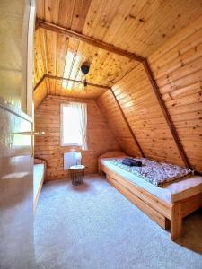 ein Schlafzimmer mit einem Bett in einem Holzzimmer in der Unterkunft The WoodHouse Vendégház in Nagymaros
