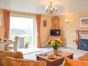 a living room with a table and a fireplace at The Hays in Burton