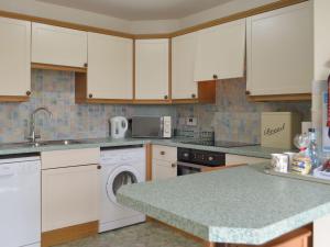 a kitchen with white cabinets and a dishwasher at The Hays in Burton