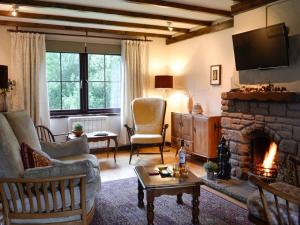 sala de estar con sofá y chimenea en Haagwood Cottage en Cretshengan