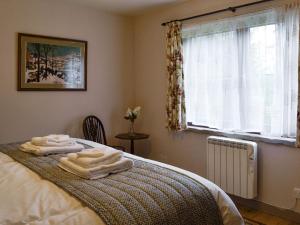 een slaapkamer met een bed met handdoeken erop bij Haagwood Cottage in Cretshengan