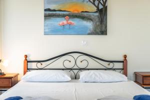 1 dormitorio con 1 cama y una pintura de 2 flamencos en Afroksilia Villa Yakinthos, en Katouna