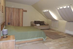 ein Schlafzimmer mit einem grünen Bett und einem Sofa in der Unterkunft Verba Tanya in Kótaj