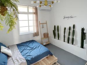 a bedroom with a bed and a window and cactus at 山蒔旁白-全台唯一電力公司48年老宿舍改造 in Yujing