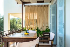 a porch with a table and chairs on a balcony at Afroksilia Villa Triantafilo in Katouna