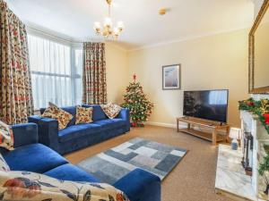 a living room with a blue couch and a christmas tree at West End Farm Lodge in Burton Agnes