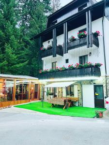 a building with a green lawn in front of it at Cabana Din Poienita in Poiana Brasov