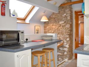 a kitchen with a counter and two stools at The Granary in Huntley