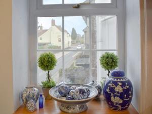 a window with three vases on a table in front of it at The Granary in Huntley