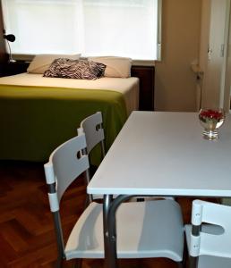 ブエノスアイレスにあるStudio Maipuのベッド、テーブル、椅子が備わる客室です。