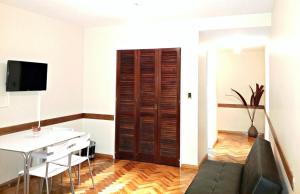 a living room with a wooden door and a table at Studio Maipu in Buenos Aires