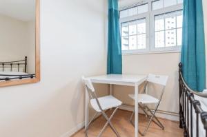 ロンドンにあるAPlaceToStay Central London Apartment, Zone 1 BONの窓のある部屋(テーブルと椅子2脚付)