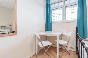 1 mesa y 2 sillas en una habitación con ventana en APlaceToStay Central London Apartment, Zone 1 BON, en Londres