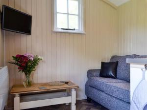 a living room with a couch and a table with flowers at Mountain View in Llanthony