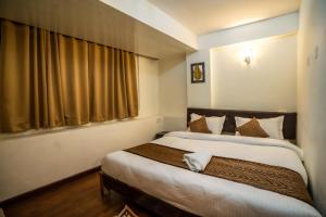 ein Schlafzimmer mit einem Bett und einem großen Fenster in der Unterkunft THE GOLDEN LEAF in Darjeeling
