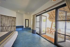 a bedroom with a bed and a view of the ocean at Xandari Pearl Beach Resort in Mararikulam