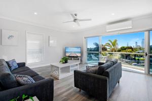sala de estar con 2 sofás y TV en 3br Broadbeach Lakefront Apartment, en Gold Coast