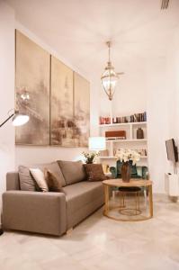 sala de estar con sofá y mesa en Precioso apartamento con patio en La Alameda, en Sevilla