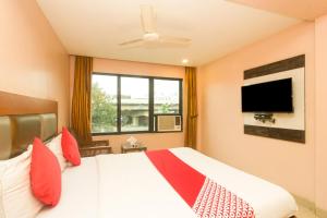 a bedroom with a large bed with a large window at OYO Hotel Sarovar Grand in Kalamboli