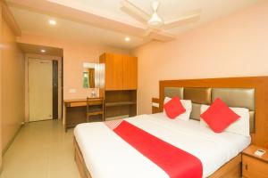 a bedroom with a large bed with red pillows at OYO Hotel Sarovar Grand in Kalamboli